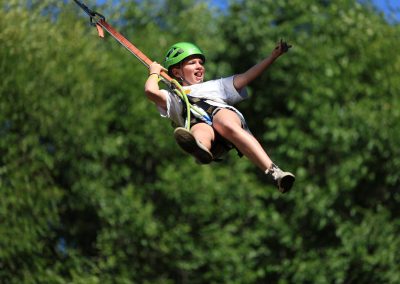 Camper flies high in the air on the Swing, feeling the joy of freedom and exhilaration of doing something new.