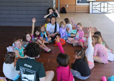 Young campers sit in a circle getting to know each other.