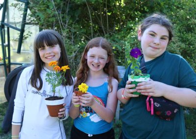 Campers plant flowers in gardening elective.